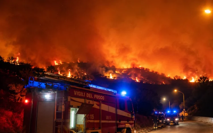 Mezzo dei Vigili del Fuoco impegnato durante un vasto incendio nei pressi di Santo Stefano Quisquina, con le fiamme che avanzano sulla collina illuminate nella notte