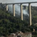 Incendio boschivo sotto il ponte Guerrieri, in via Fiumara tra Modica e Scicli, con colonne di fumo che si alzano dalla vegetazione mentre sono in corso le operazioni di spegnimento