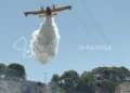 Un canadair effettua un lancio d'acqua sull'incendio che interessa la collina di Monserrato, a Modica, durante le operazioni di spegnimento