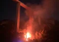 Incendio sul costone di Monserrato a Modica durante la notte con fiamme visibili sotto il viadotto