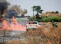 Vigili del fuoco e Protezione Civile impegnati nello spegnimento di un vasto incendio di sterpaglie a Santa Croce Camerina, con alte fiamme e una densa colonna di fumo.
