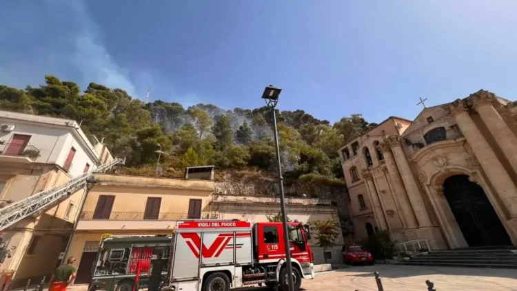 Mezzi dei Vigili del Fuoco davanti al Santuario della Madonna delle Grazie di Modica mentre un incendio interessa la collina di Monserrato.