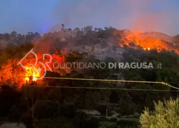 Vasto incendio sulla collina di Monserrato a Modica, con diversi focolai attivi tra la vegetazione e una densa colonna di fumo al tramonto