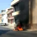 Veicolo in fiamme contro un edificio in una via residenziale di Comiso, con densa colonna di fumo nero che sale verso il cielo