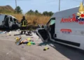 Un vigile del fuoco tra i due furgoni distrutti dopo lo scontro frontale sulla provinciale Valguarnera-Dittaino