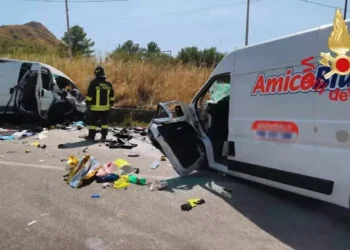 Un vigile del fuoco tra i due furgoni distrutti dopo lo scontro frontale sulla provinciale Valguarnera-Dittaino