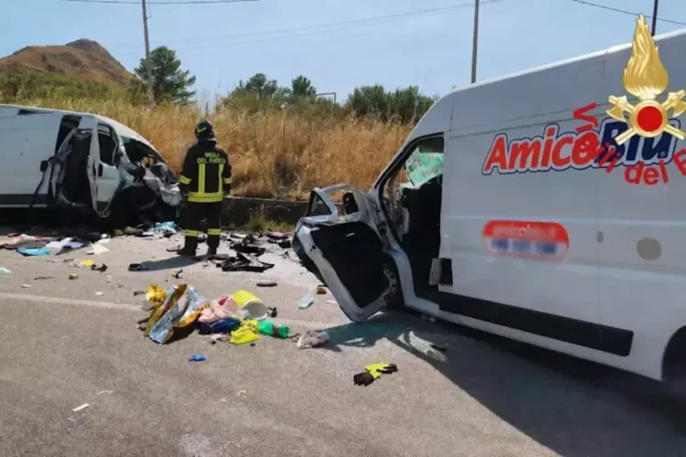 Un vigile del fuoco tra i due furgoni distrutti dopo lo scontro frontale sulla provinciale Valguarnera-Dittaino