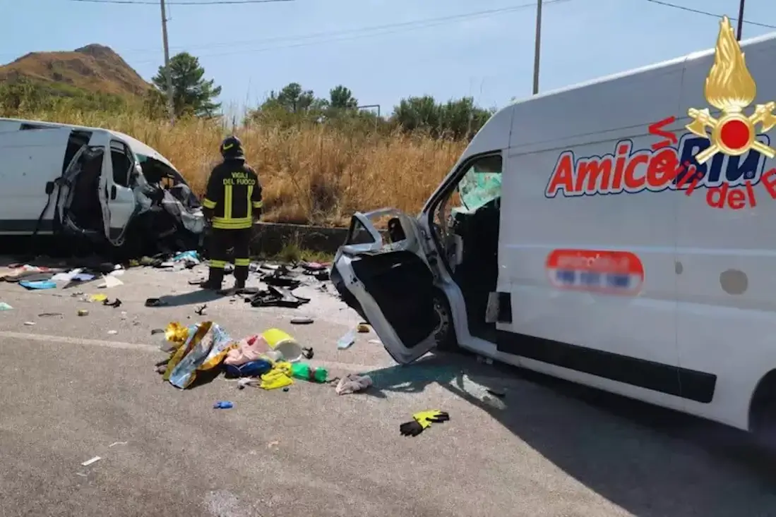 Un vigile del fuoco tra i due furgoni distrutti dopo lo scontro frontale sulla provinciale Valguarnera-Dittaino