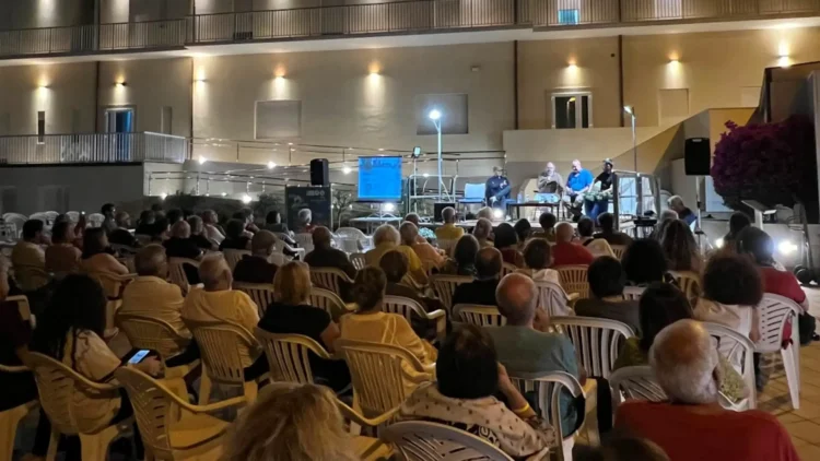 Pubblico assiste a un incontro della rassegna Liolà 2026 nel Giardino delle Suore del Sacro Cuore a Marina di Ragusa.