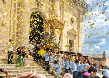 Portatori in azzurro reggono il fercolo della Madonna della Neve sotto una pioggia di coriandoli gialli a Giarratana