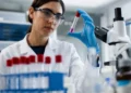 Scienziata in un laboratorio di genetica osserva una provetta con un campione biologico durante un'attività di ricerca sulle malattie genetiche rare.