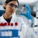 Scienziata in un laboratorio di genetica osserva una provetta con un campione biologico durante un'attività di ricerca sulle malattie genetiche rare.