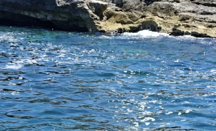 Scorcio del mare di Cava d'Aliga con acqua limpida e costa rocciosa sullo sfondo