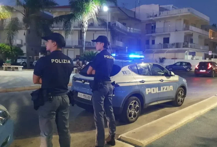 Agenti della Polizia di Stato accanto a una volante durante un servizio di controllo a Marina di Ragusa