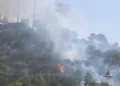 Fumo e fiamme tra la vegetazione nella zona di Monserrato, a Modica, durante la ripresa dell'incendio con intervento dei mezzi antincendio.
