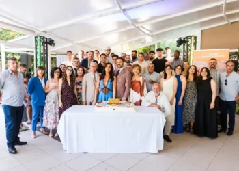 Foto di gruppo durante la celebrazione dei 18 anni di San Gregorio a Modica, con dipendenti, clienti, docenti universitari e il taglio della torta