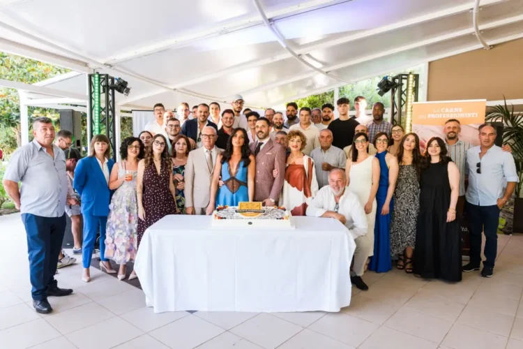 Foto di gruppo durante la celebrazione dei 18 anni di San Gregorio a Modica, con dipendenti, clienti, docenti universitari e il taglio della torta