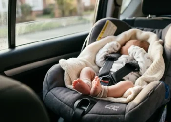 Neonato in ovetto allacciato nel sedile posteriore di un'auto. Immagine di repertorio