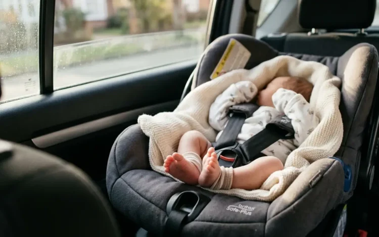 Neonato in ovetto allacciato nel sedile posteriore di un'auto. Immagine di repertorio