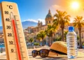 Termometro che segna oltre 40 gradi davanti a un paesaggio urbano siciliano illuminato dal sole, simbolo dell'ondata di calore e del rischio incendi