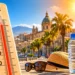 Termometro che segna oltre 40 gradi davanti a un paesaggio urbano siciliano illuminato dal sole, simbolo dell'ondata di calore e del rischio incendi