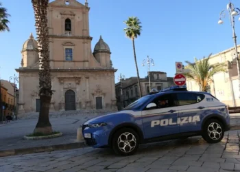 Auto della Polizia di Stato parcheggiata in piazza a Vittoria davanti a una chiesa del centro storico durante un servizio di polizia