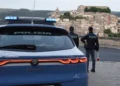 Auto della Polizia di Stato e due agenti impegnati in un servizio di controllo con vista sul centro storico di Ragusa Ibla.