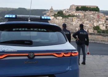 Auto della Polizia di Stato e due agenti impegnati in un servizio di controllo con vista sul centro storico di Ragusa Ibla.