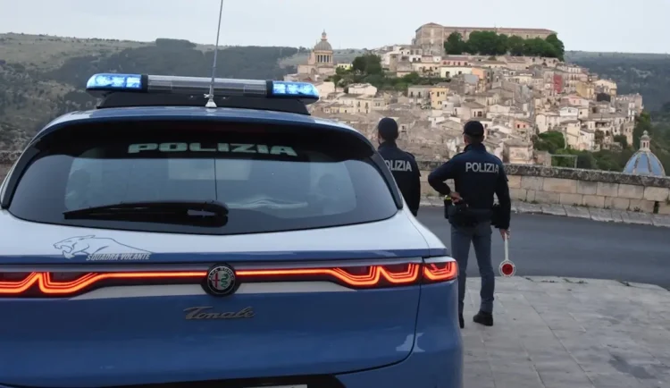 Auto della Polizia di Stato e due agenti impegnati in un servizio di controllo con vista sul centro storico di Ragusa Ibla.