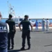Agenti della Squadra Mobile della Polizia di Stato e militari della Guardia di Finanza nel porto di Pozzallo durante le operazioni successive allo sbarco di 86 migranti