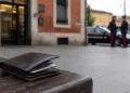 Portafogli ritrovato nei pressi della stazione ferroviaria di Guastalla con una pattuglia dei carabinieri sullo sfondo.