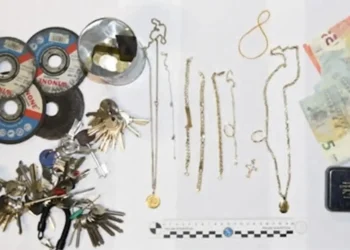 Foto della Polizia di Stato con il materiale sequestrato durante un'indagine per furto in abitazione a Ragusa: banconote in euro, gioielli, mazzi di chiavi, dischi da taglio, martelli, un piede di porco e altri attrezzi da scasso disposti su un tavolo.