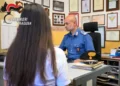 Una donna sporge denuncia presso la caserma dei Carabinieri di Ragusa mentre un militare raccoglie la sua testimonianza nell'ambito delle indagini sulla truffa del finto carabiniere