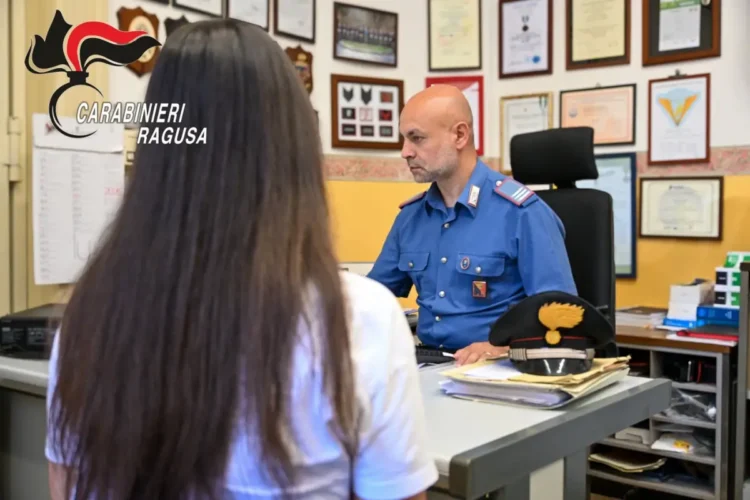 Una donna sporge denuncia presso la caserma dei Carabinieri di Ragusa mentre un militare raccoglie la sua testimonianza nell'ambito delle indagini sulla truffa del finto carabiniere