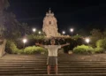 Red Ronnie posa con le braccia aperte sulla scalinata del Duomo di San Giorgio a Modica, illuminato di sera durante la sua vacanza in provincia di Ragusa