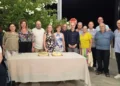 Gli ex studenti della classe V D dell'ITC Archimede di Modica posano insieme ai loro docenti durante la reunion organizzata a 40 anni dal diploma, davanti al tavolo con le torte celebrative