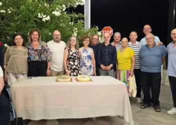 Gli ex studenti della classe V D dell'ITC Archimede di Modica posano insieme ai loro docenti durante la reunion organizzata a 40 anni dal diploma, davanti al tavolo con le torte celebrative