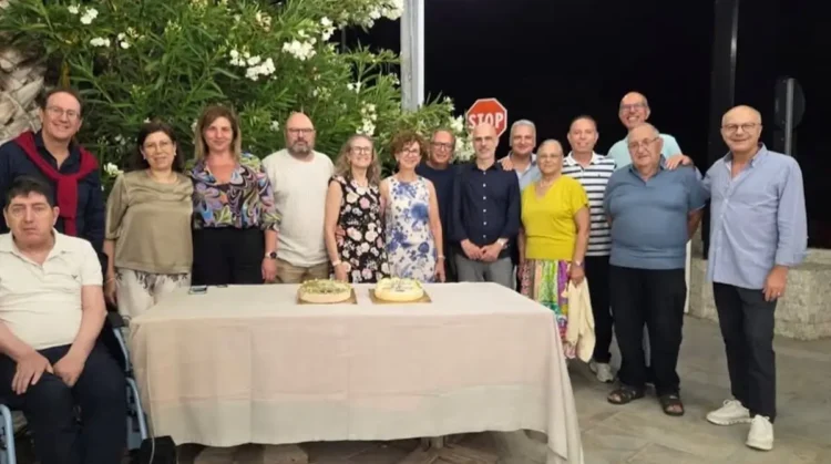 Gli ex studenti della classe V D dell'ITC Archimede di Modica posano insieme ai loro docenti durante la reunion organizzata a 40 anni dal diploma, davanti al tavolo con le torte celebrative