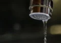 Primo piano di un rubinetto da cui esce un sottile filo d'acqua, immagine simbolo dei disagi legati alla carenza idrica e ai blackout