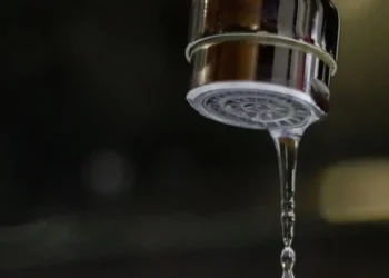 Primo piano di un rubinetto da cui esce un sottile filo d'acqua, immagine simbolo dei disagi legati alla carenza idrica e ai blackout