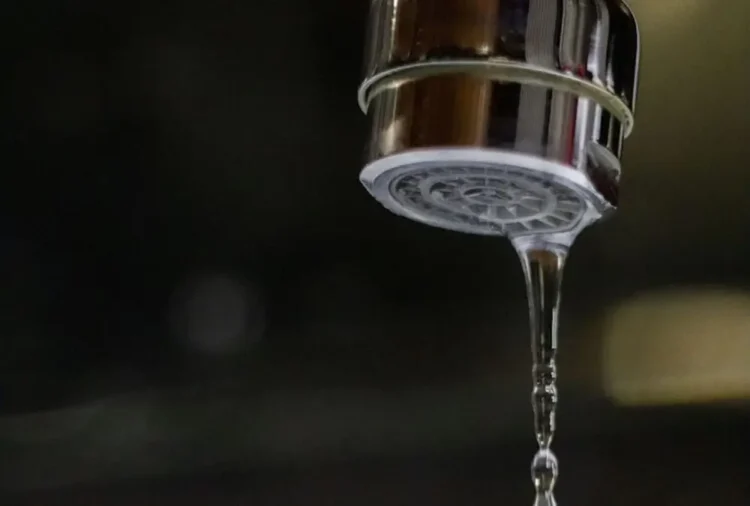 Primo piano di un rubinetto da cui esce un sottile filo d'acqua, immagine simbolo dei disagi legati alla carenza idrica e ai blackout