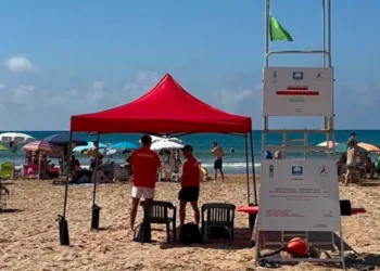 Due assistenti bagnanti in maglietta rossa sorvegliano la spiaggia di Marina di Ragusa accanto alla torretta di avvistamento