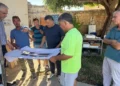 Ignazio Abbate e i tecnici durante un sopralluogo al cantiere del Tennis Club Scicli mentre esaminano le planimetrie dei lavori di riqualificazione finanziati dalla Regione Siciliana.