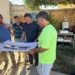 Ignazio Abbate e i tecnici durante un sopralluogo al cantiere del Tennis Club Scicli mentre esaminano le planimetrie dei lavori di riqualificazione finanziati dalla Regione Siciliana.