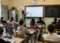 Docente durante una lezione in una scuola italiana con studenti in aula dopo il rinnovo del contratto nazionale del comparto Istruzione