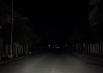 Strada urbana di Pozzallo completamente al buio durante un blackout elettrico, con illuminazione pubblica assente e carreggiata deserta nelle ore notturne.