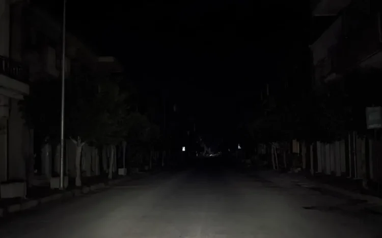 Strada urbana di Pozzallo completamente al buio durante un blackout elettrico, con illuminazione pubblica assente e carreggiata deserta nelle ore notturne.
