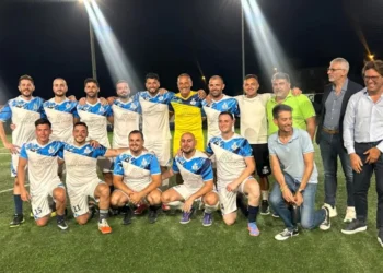 La squadra della Polizia Penitenziaria di Ragusa posa sul campo da calcio dopo la vittoria per 3-0 nella finale del Torneo delle Professioni 2026, insieme ad alcuni rappresentanti dell'amministrazione comunale durante la premiazione.