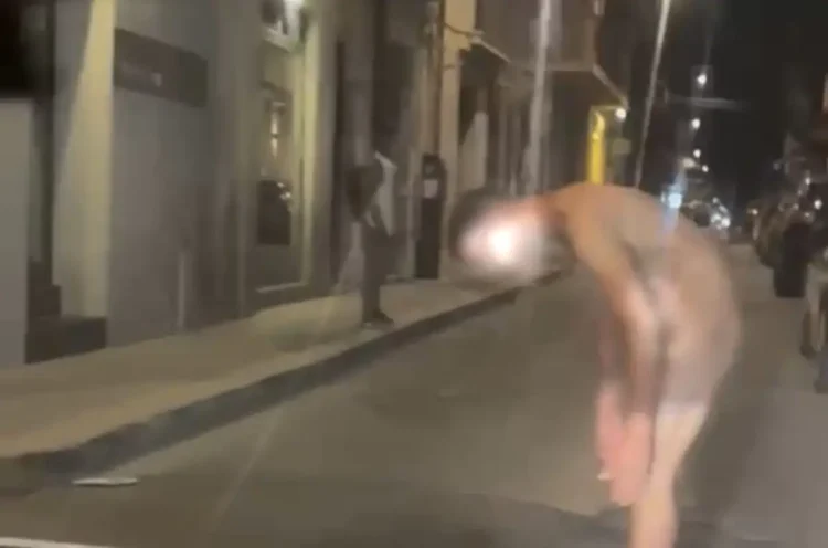 Un uomo, con il volto oscurato per tutelarne la privacy, è fermo al centro di una strada di Vittoria durante le ore serali. L'immagine documenta l'episodio che ha richiesto l'intervento dei Carabinieri.