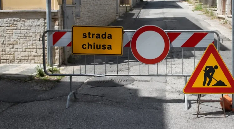 Transenna con cartello "strada chiusa" e segnale di divieto d'accesso davanti a una via bloccata per lavori in corso